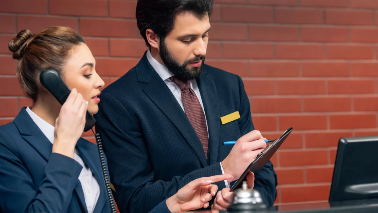 concentrated hotel receptionists receiving call from customer at workplace