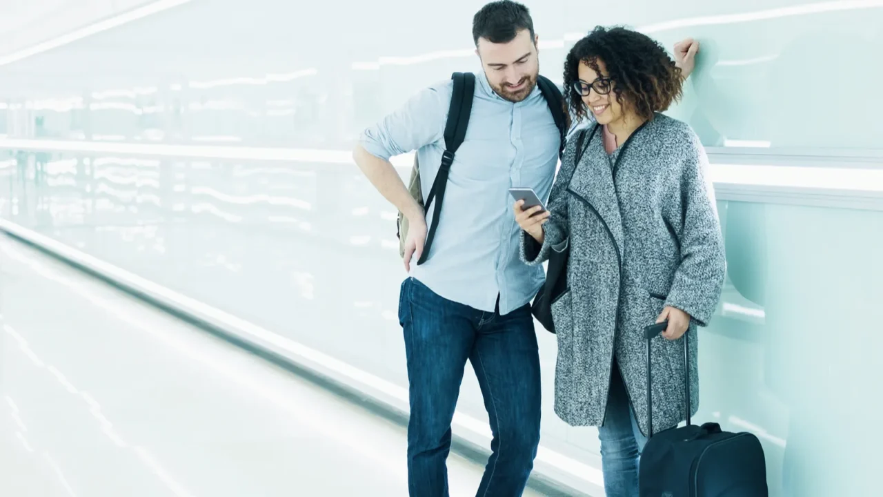 couple ready to go on vacation using travel app on