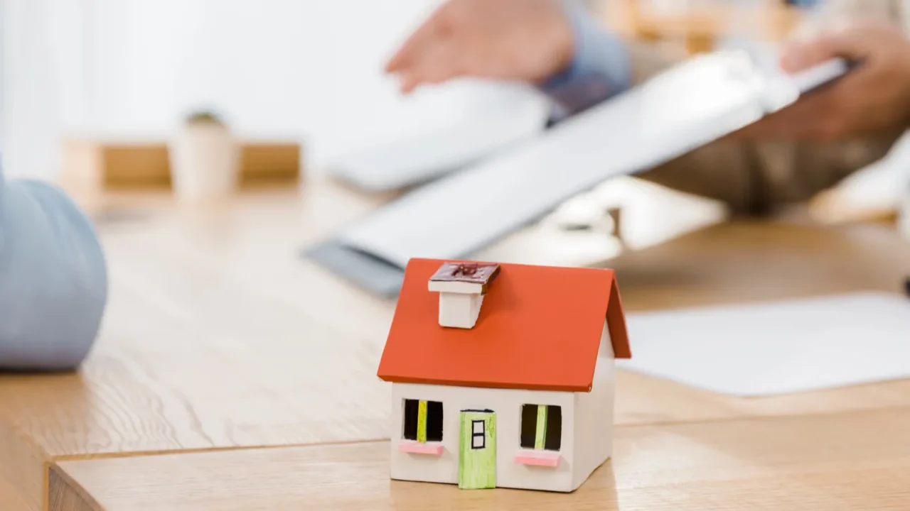 house model on wooden table with blurred people at background