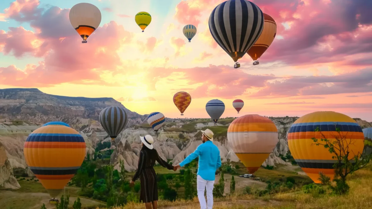 kapadokya cappadocia turkey a happy young couple during sunrise watching