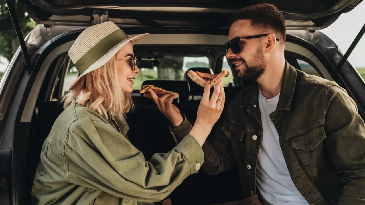 man and woman sitting in the trunk of car and