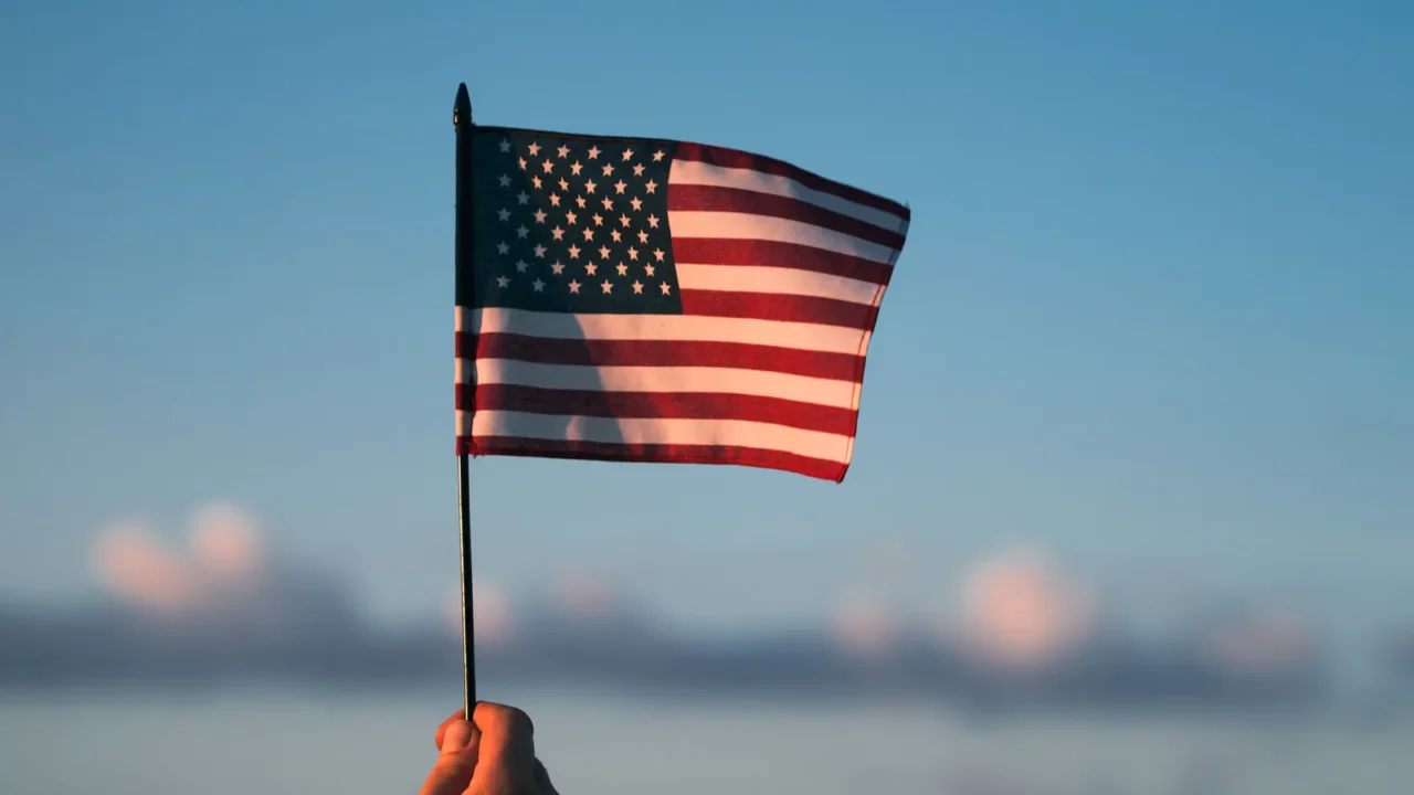 man holding american usa flag in the sunset independence day