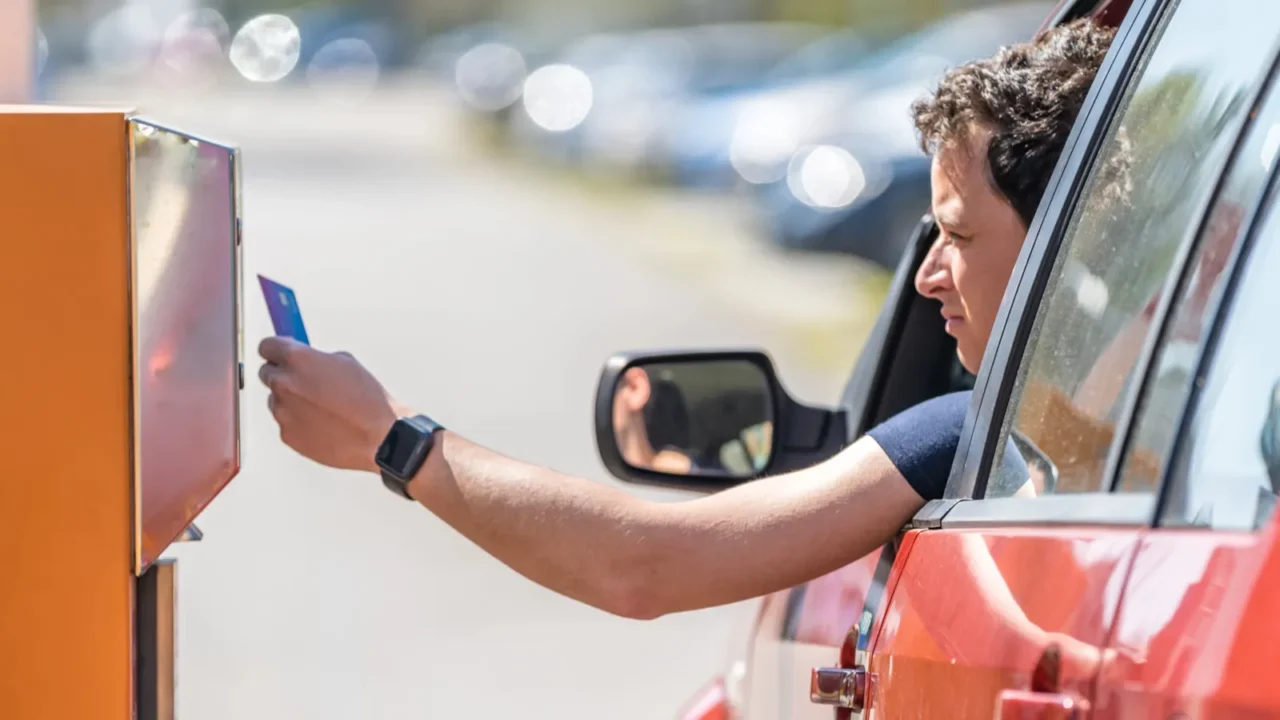 man pays by credit card parking in the parking meter