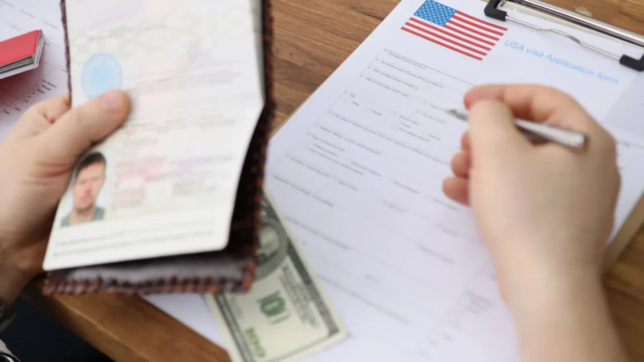 people filling visa application forms with personal passports at embassy