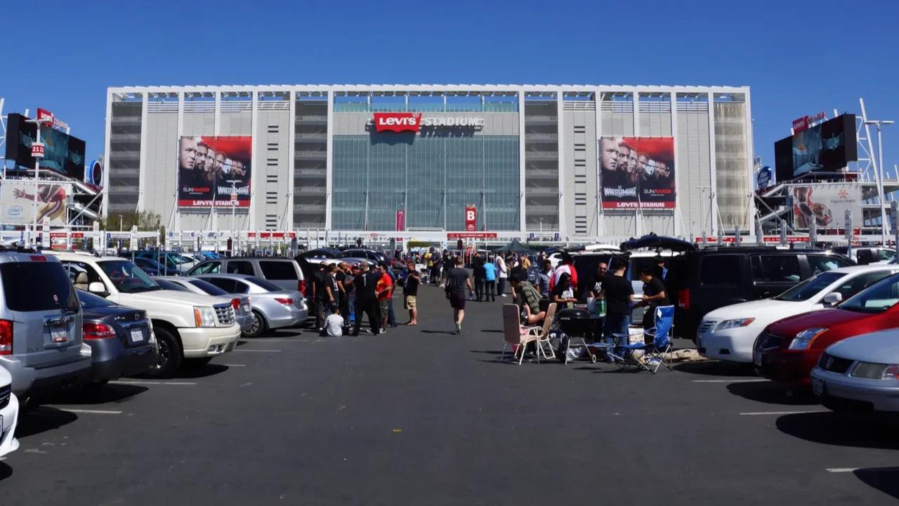 people tailgate in parking lot before the start of the