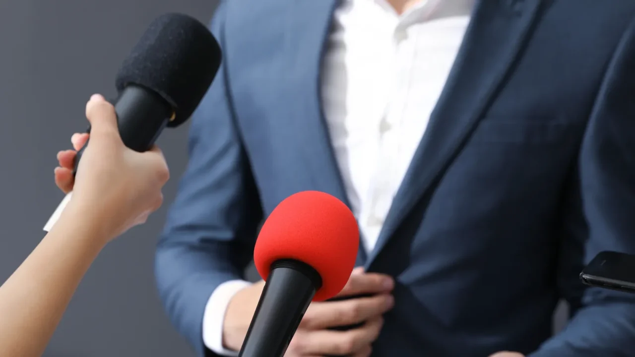 professional journalists interviewing businessman on grey background closeup