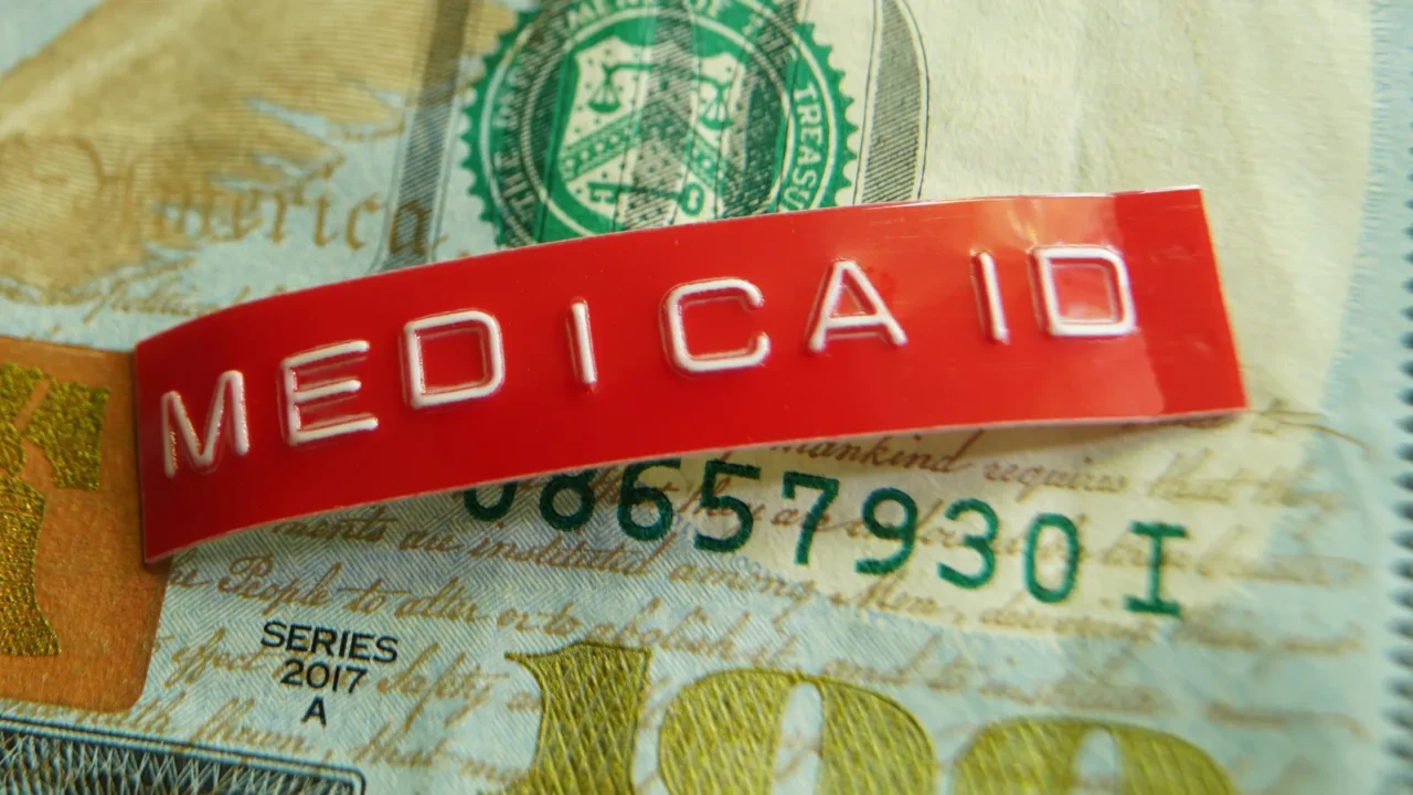 red medicaid label on a us hundred dollar bill