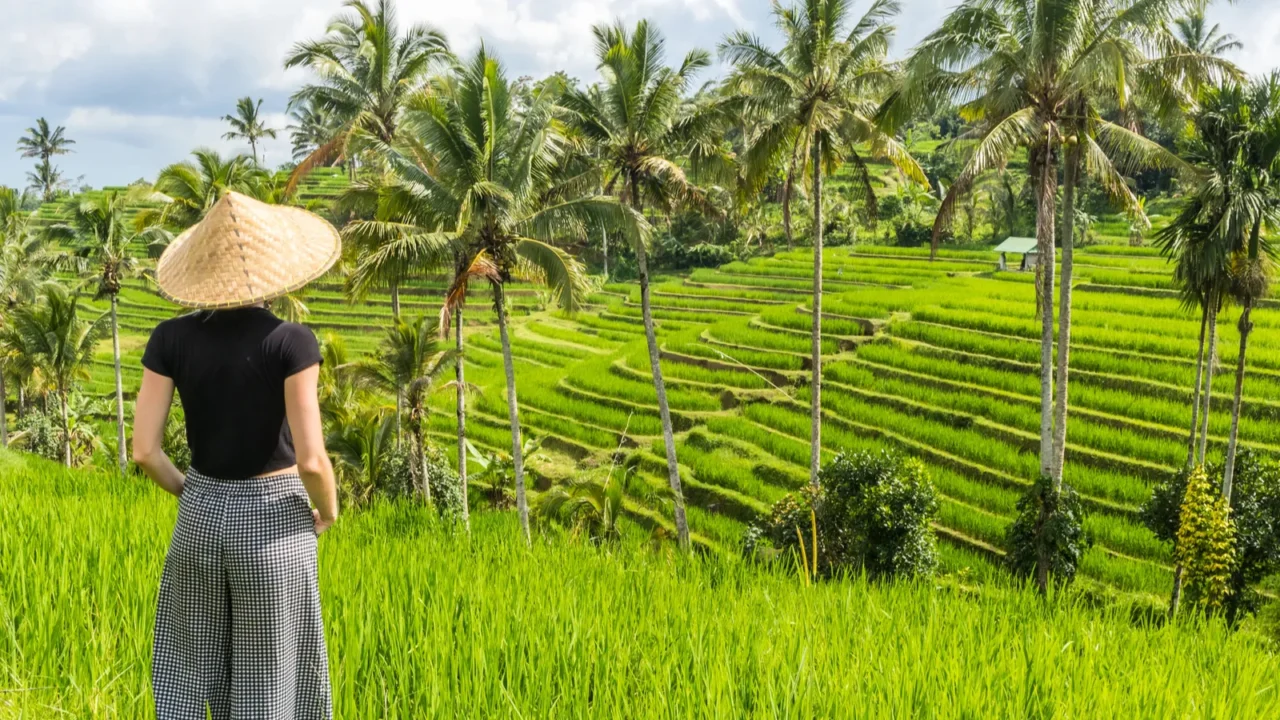 relaxed fashionable caucasian female tourist wearing small backpack and traditional