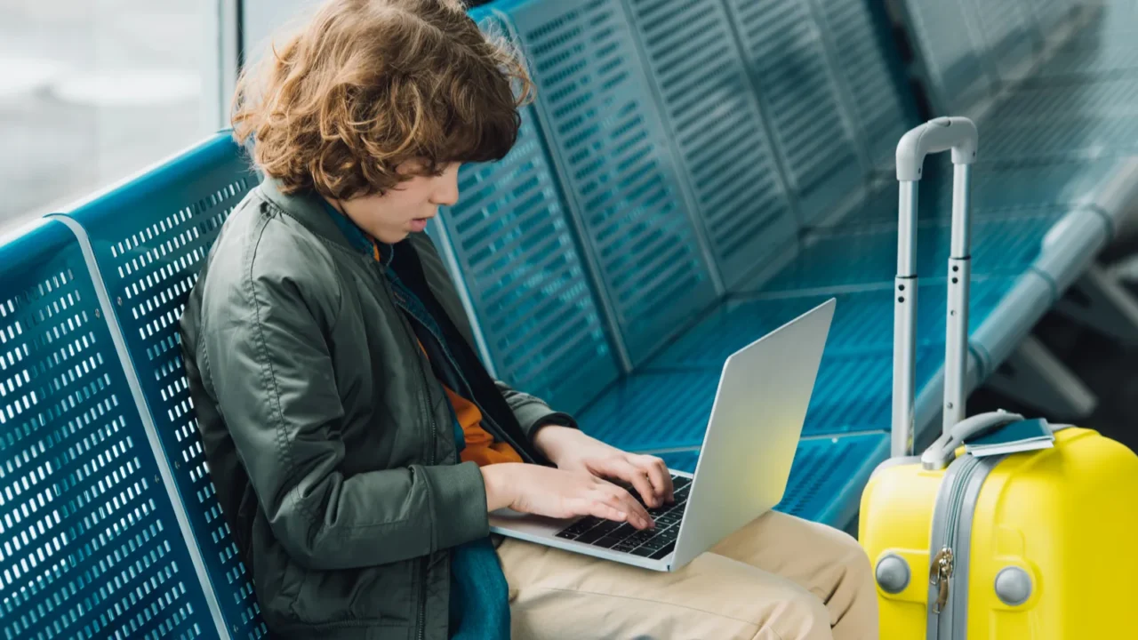 side view of boy typing on laptop and sitting on