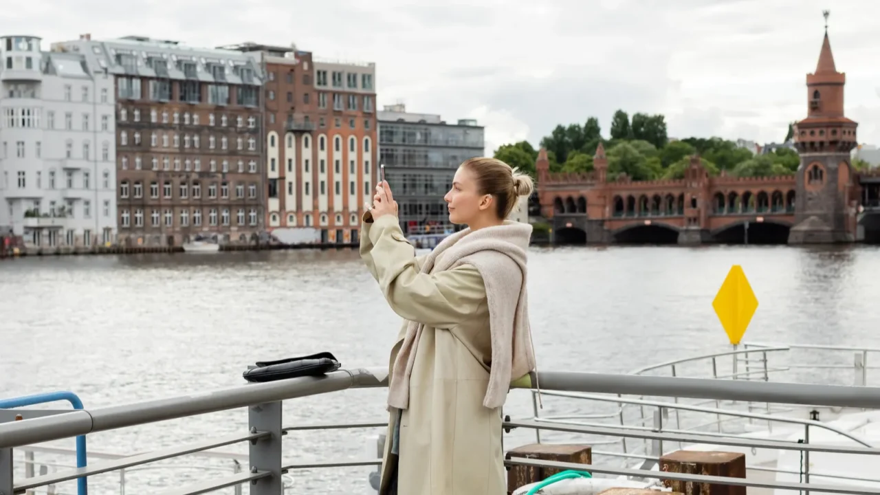 side view of young woman taking photo on pier in