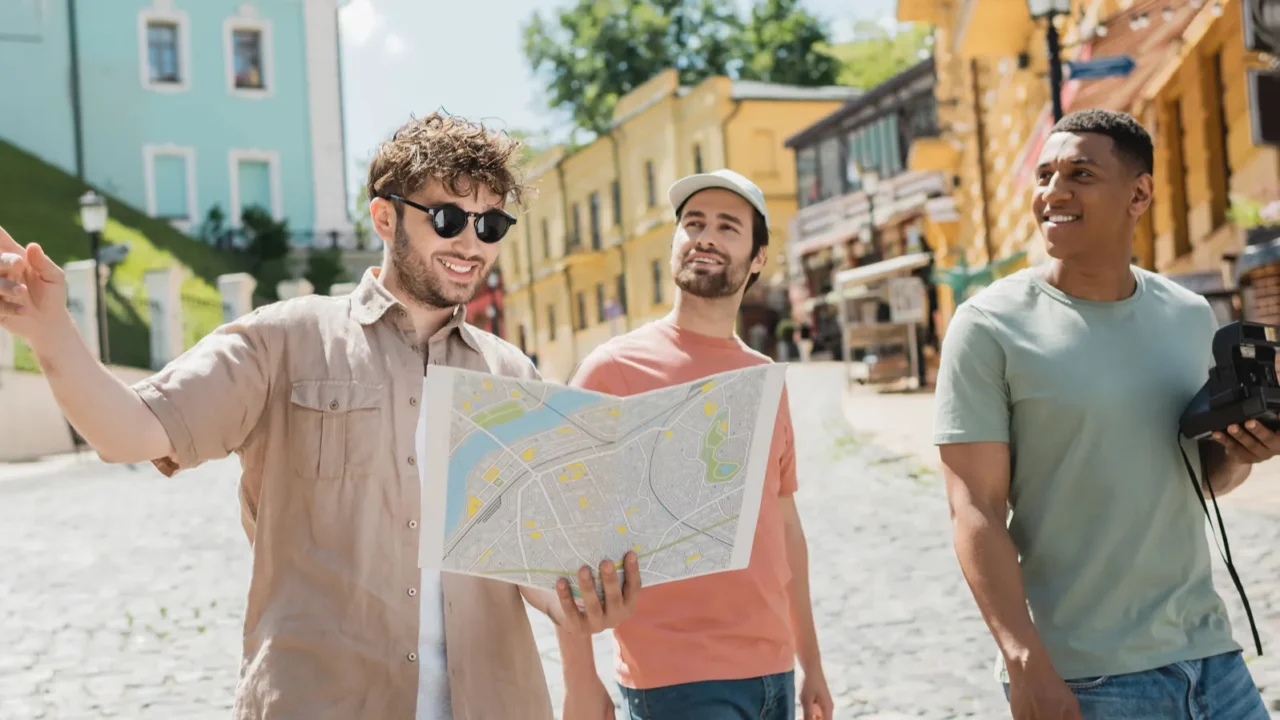 smiling guide in sunglasses looking at map and pointing with