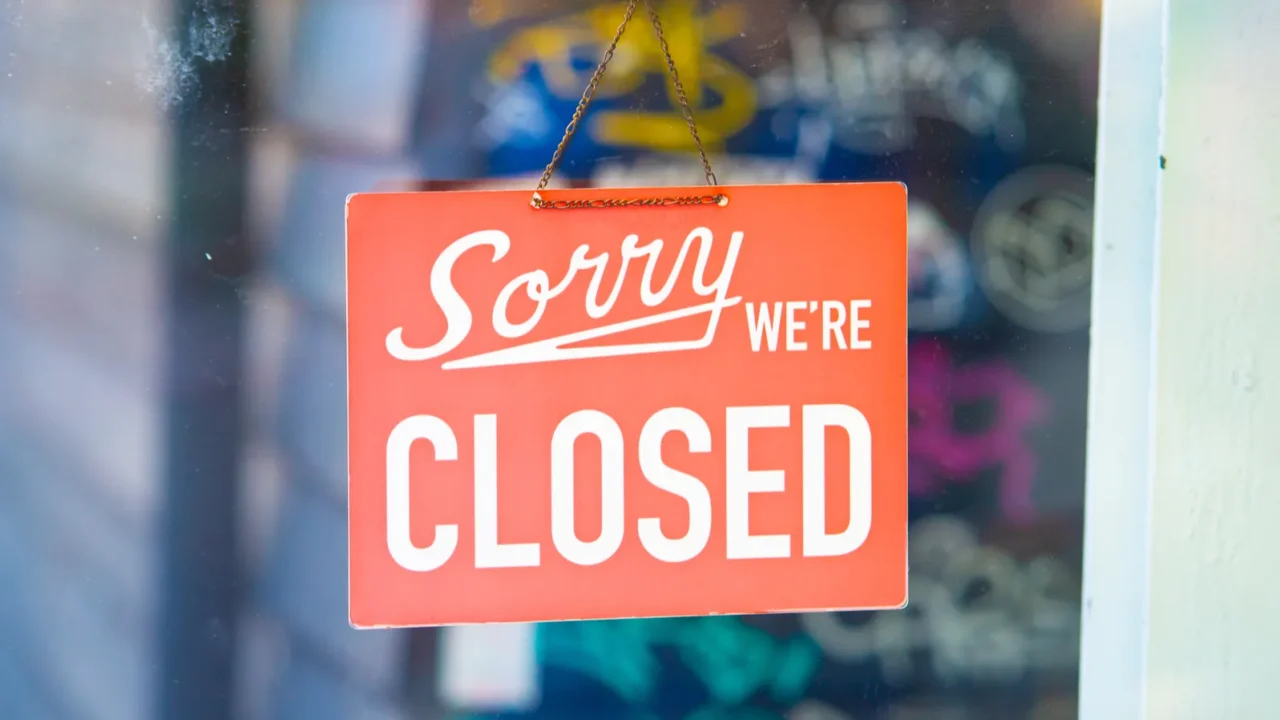 "Sorry, we're closed" sign on restaurant door.