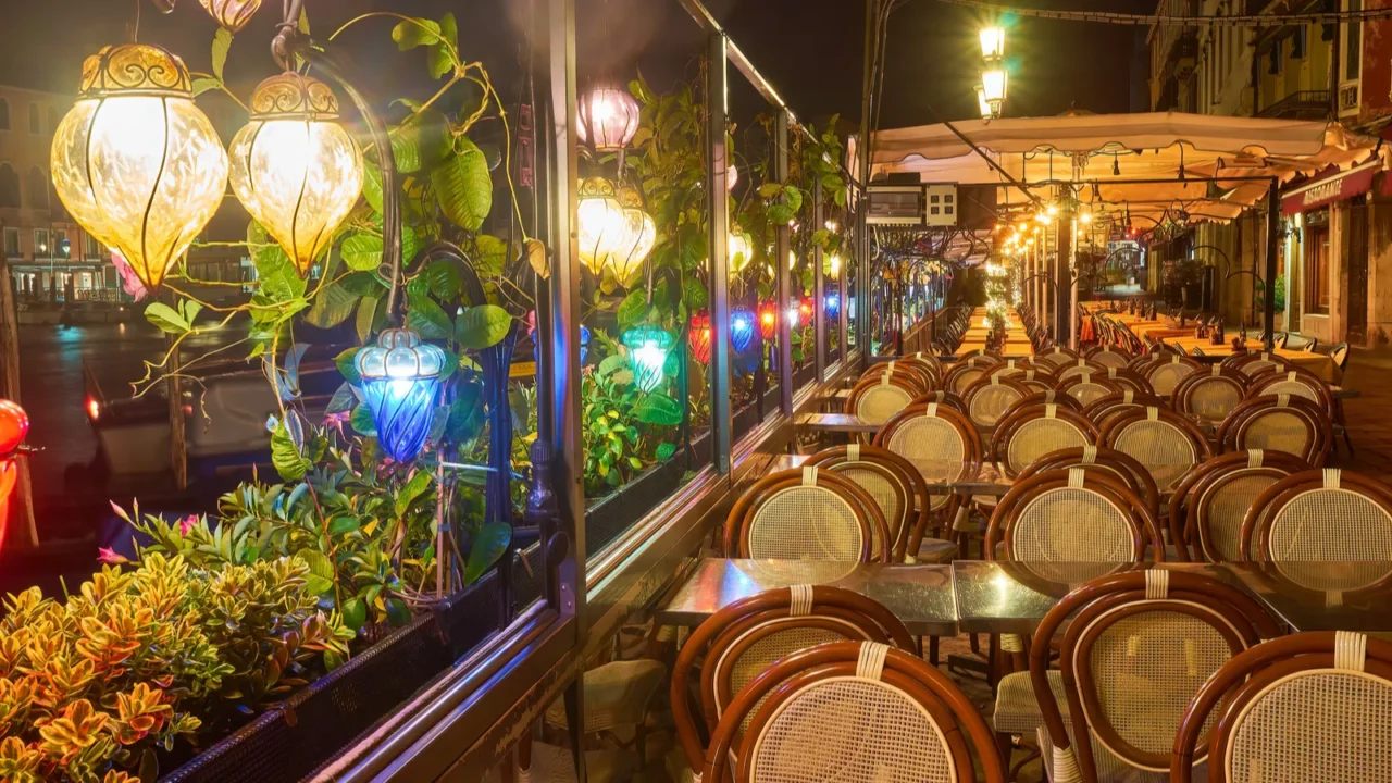 street with bridge and tables of restaurant in venice italy