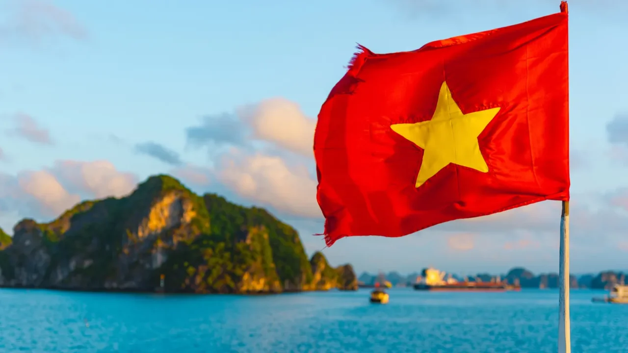 the red flag of vietnam waves on a boat sailing