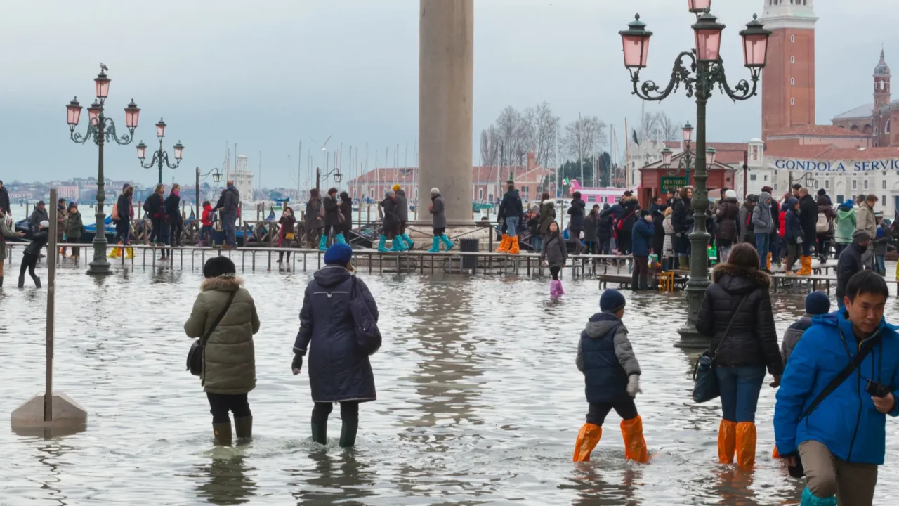 tourists in san marco square with high tide venice italy