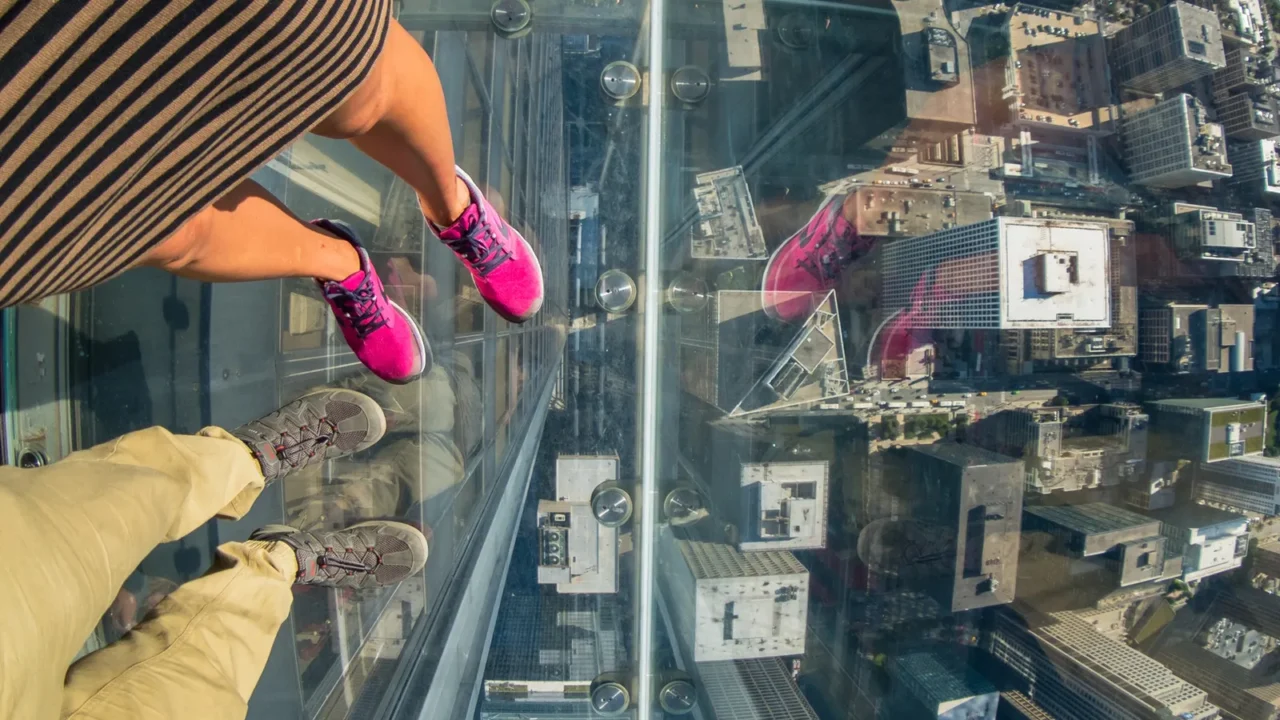 tourists posing on a glass floor