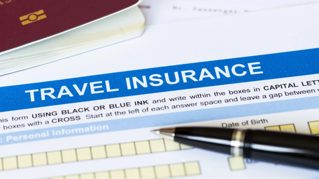 travel insurance application form with pen and passport