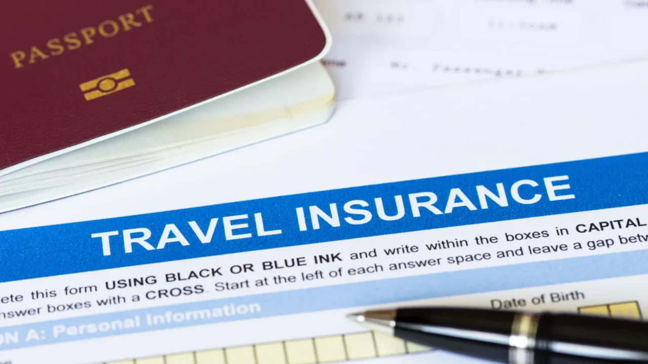 travel insurance application form with pen and passport