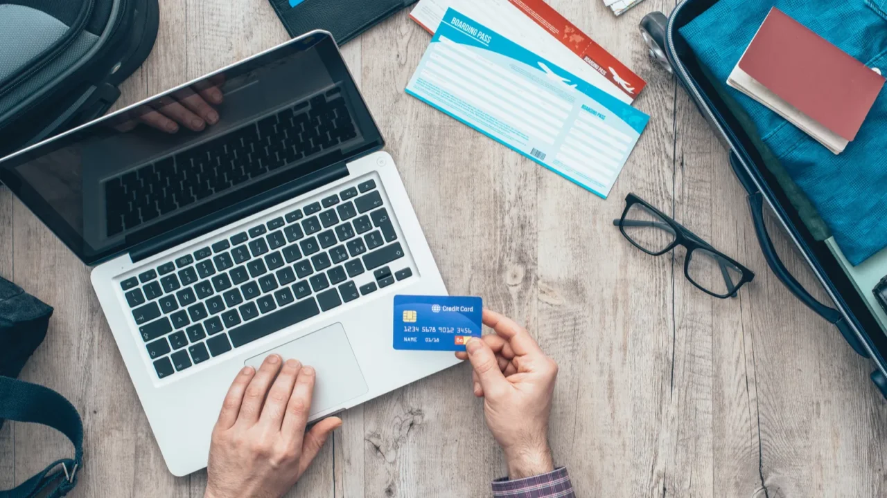 traveler packing bag and booking flight