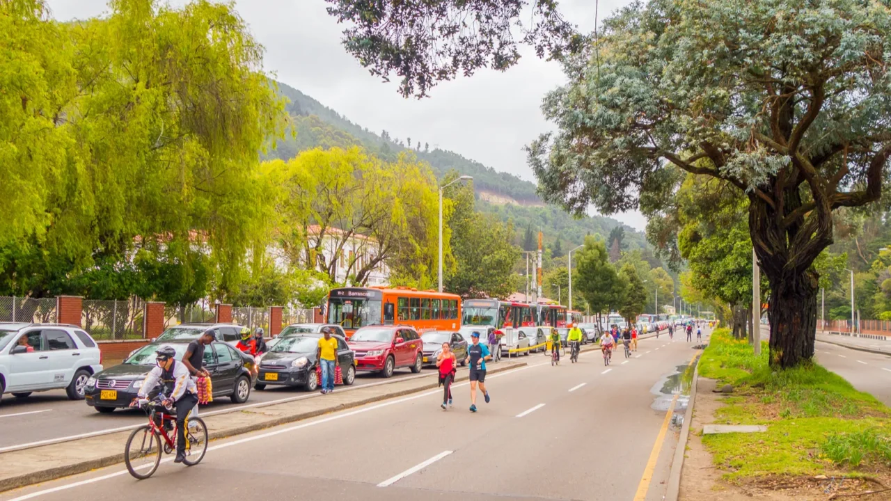 unidentified hispanic cyclists moving through vehicle free street with heavy