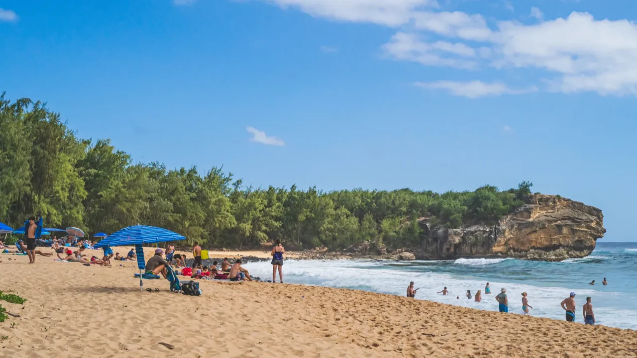 view of shipwreck beach as tourists enjoy the pacific ocean
