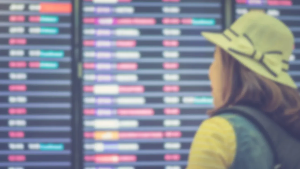 woman backpacker see at the flight board in the airport