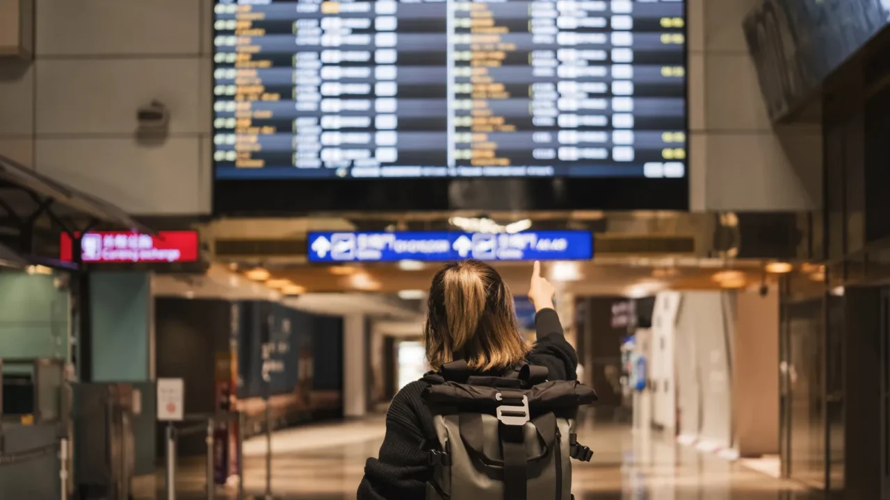 young asian woman in international airport looking at flight information