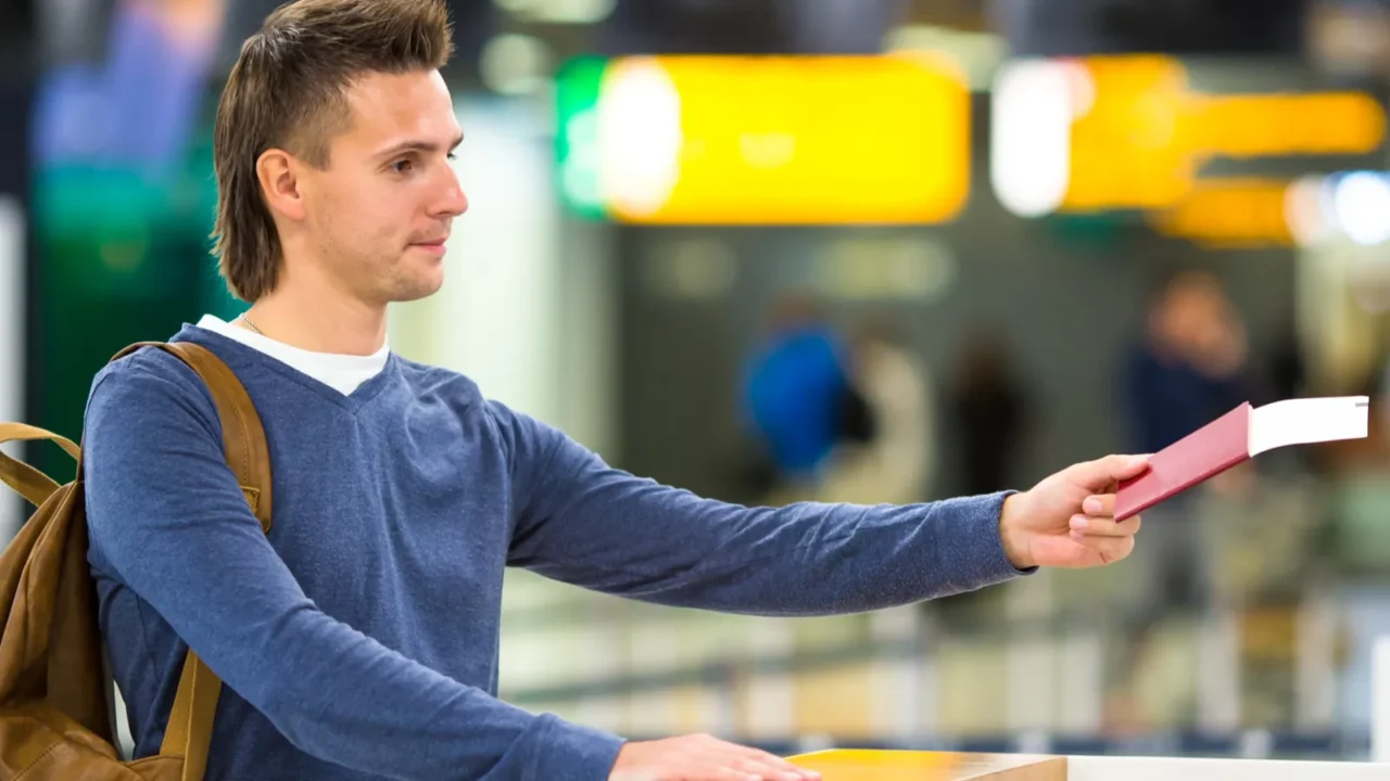 young man with passports and boarding passes at the front