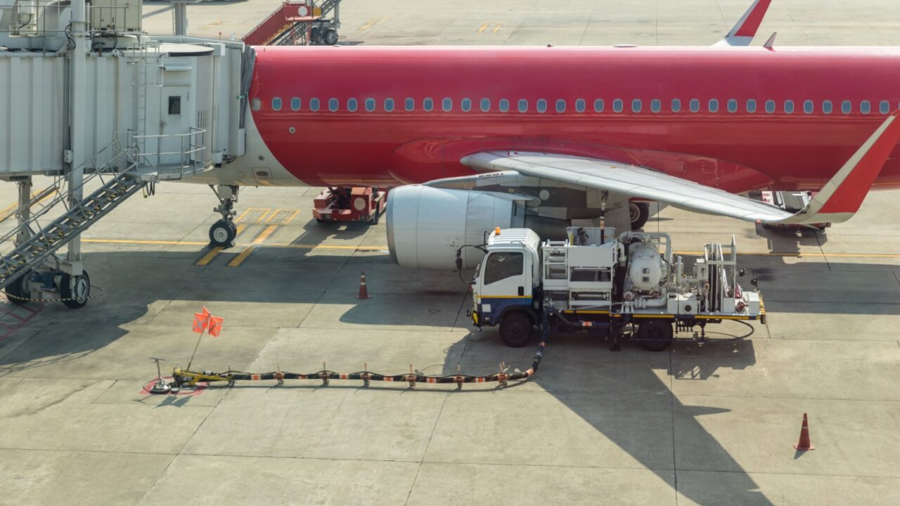 Aircraft refueling by high pressure fuel supply truck. Refueling operation of large widebody passenger aircraft standing on airport's parking place . Refueling of the airplane before flight.