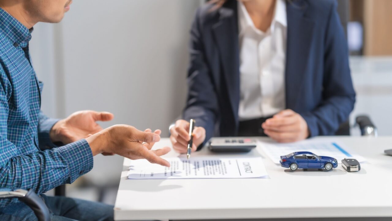 Asian businesswoman specializing in car loan services. Proficient in terms like extended warranty, lease, MSRP, and navigating financing options for customers' automotive needs.