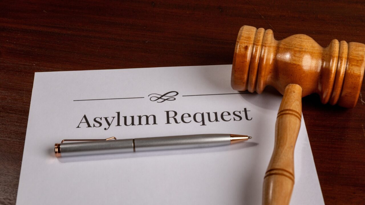 Asylum Request Form on Wooden Desk with Gavel – Immigration and Refugee Law Concept