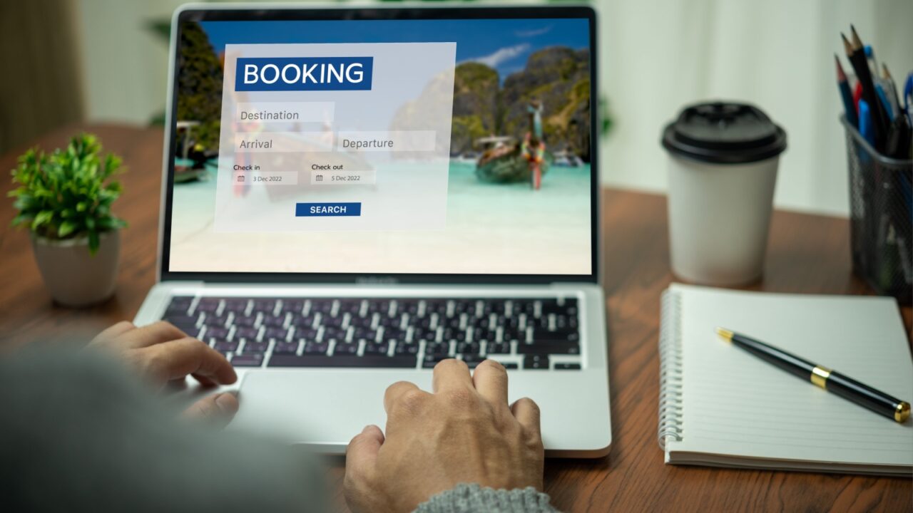 Online booking platform on a laptop computer by a person. Man use websites to search for accommodation, hotels and airlines for their vacation trips or buy tours on the Internet.