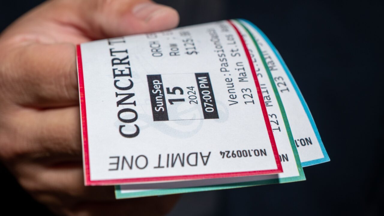 A man is engaged in ticket scalping, selling concert tickets at a significantly higher price than face value