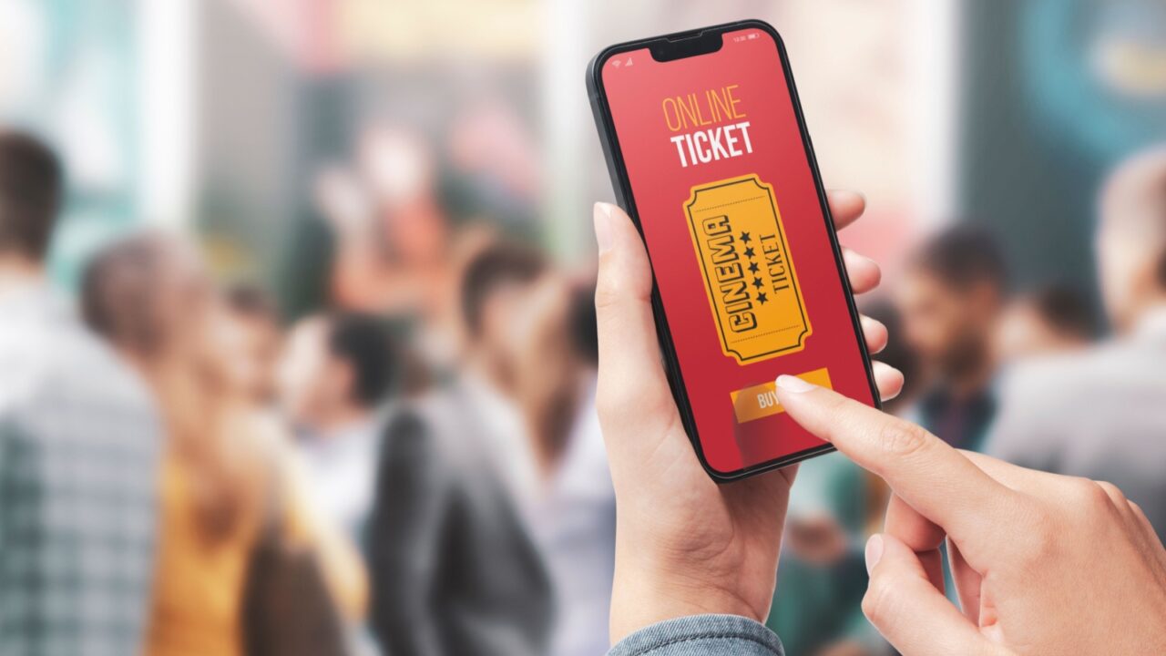 Woman holding a smartphone and buying movie tickets online using a mobile app, she is skipping the queue