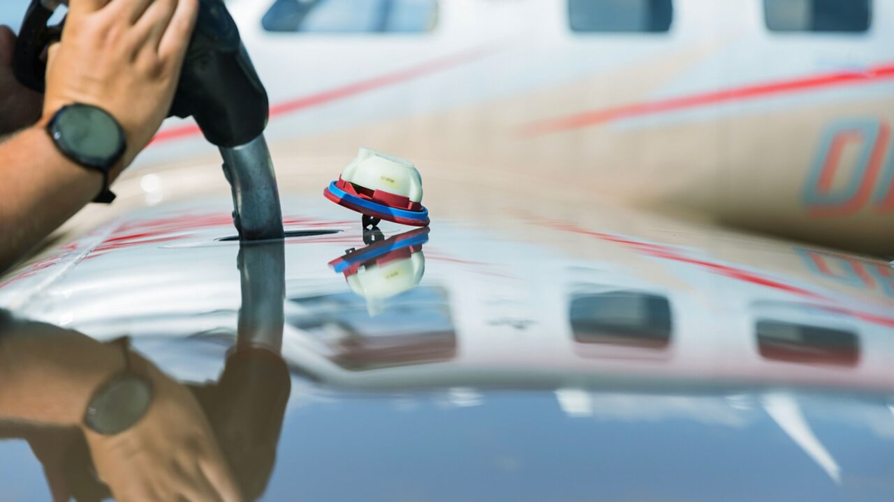 Fuel nozzle filling up aircraft, refueling jet fuel in an aircraft wing, Focused on refueling gun. Focused on refueling gun
