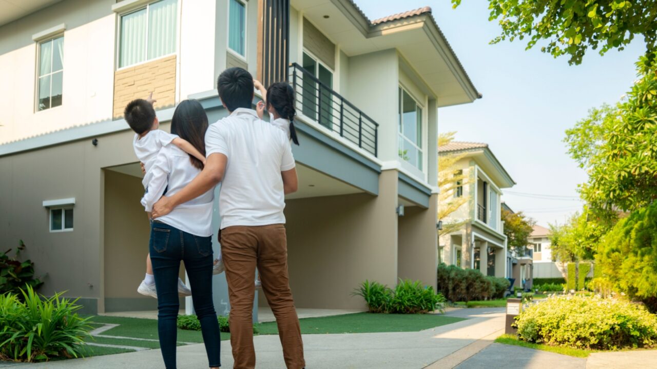 Beautiful family portrait smiling outside their new house with sunset, this photo canuse for family, father, mother and home concept