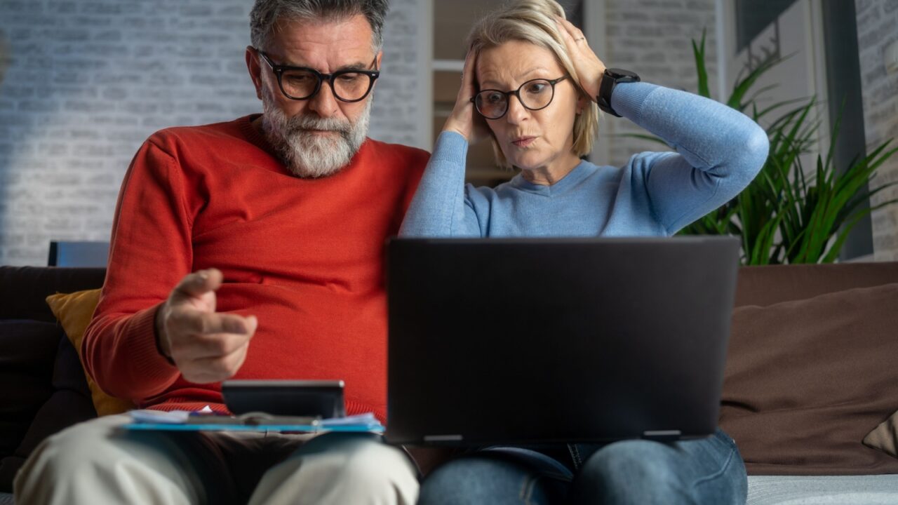 Couple upset headache depressed from family cost got higher holding receipts from supermarket with calculator by rising grocery prices and surging cost as an inflation financial crisis.