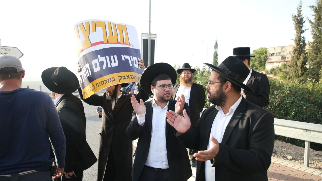 SAFED, ISRAEL -OCT 19, 2017: Ultra orthodox Jewish men protest for the release of a religious Jewish youth who was jailed for refusing to serve in the military, at the street entrance to Safed, Israel