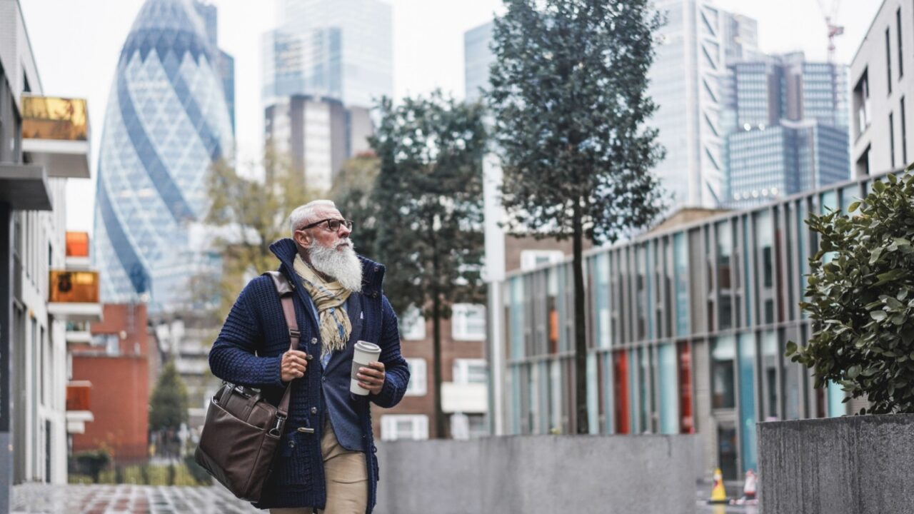 Senior businessman walking to work - Hipster entrepreneur drinking coffee while going to office - Job, business, elegant, fashion and confident concept - Focus on face