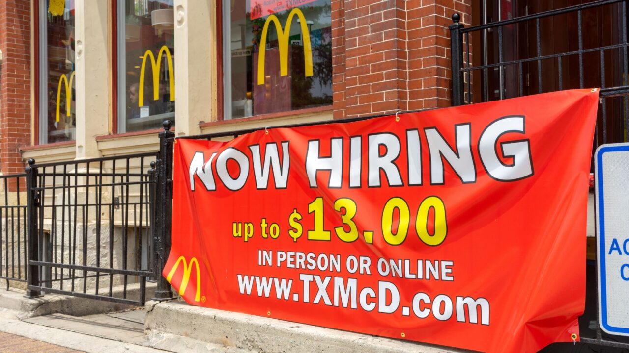 San Antonio, Texas, USA – May 8, 2023: A Now Hiring banner sign at a downtown McDonald's restaurant in San Antonio, Texas.