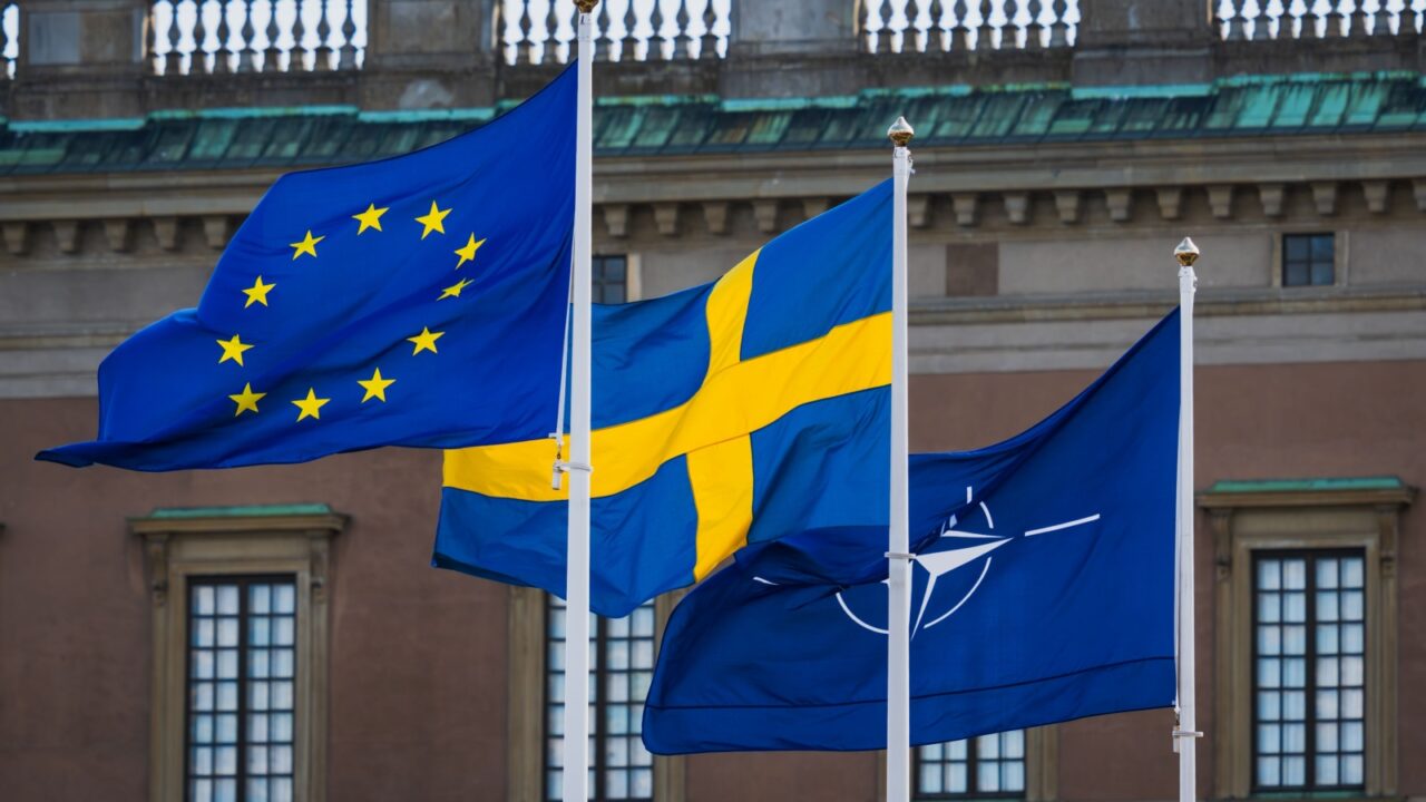 STOCKHOLM, SWEDEN – APRIL 4, 2025: Flags of the European Union, Sweden, and NATO fly together symbolizing alliance memberships.