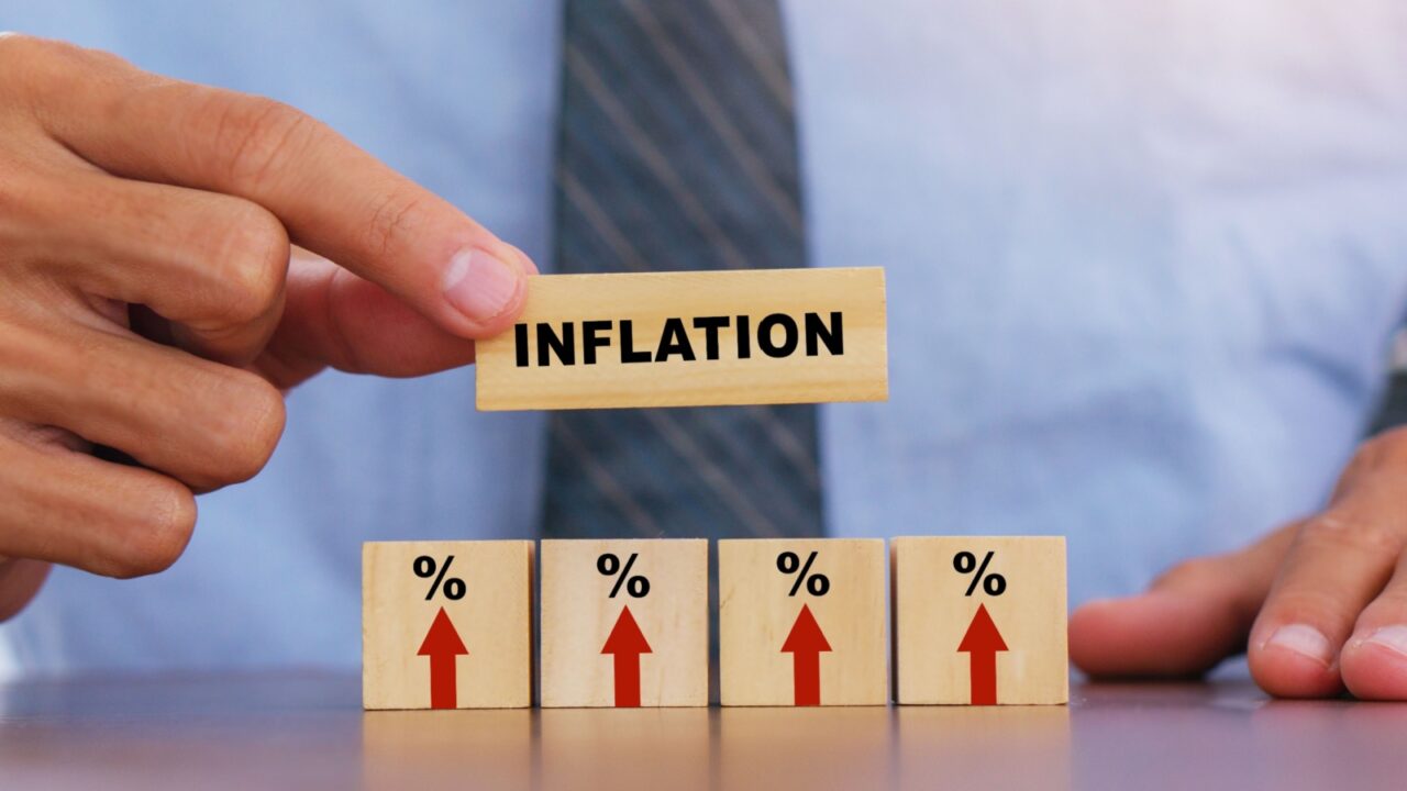 Hand putting wooden cube and inflation word.Idea for FED consider interest rate hike, world economics, and inflation control, US dollar inflation.