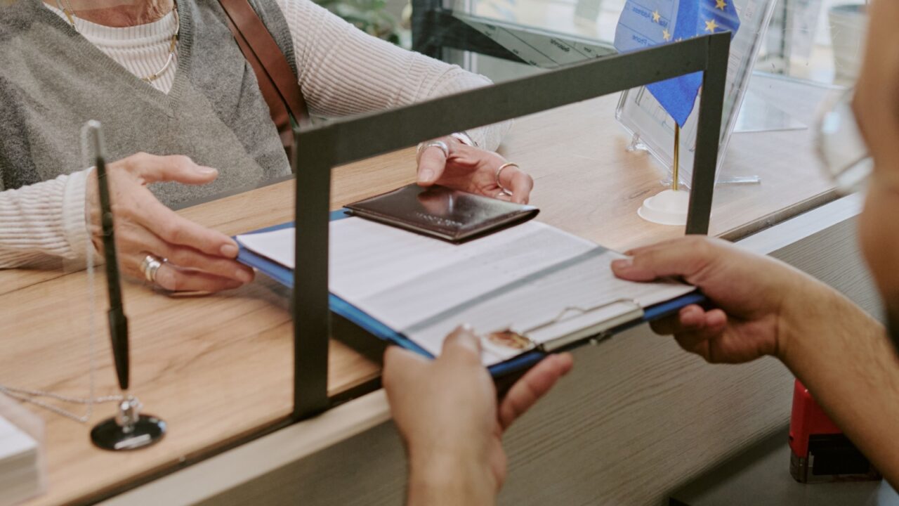 Unrecognizable woman getting her visa application and passport back in visa center