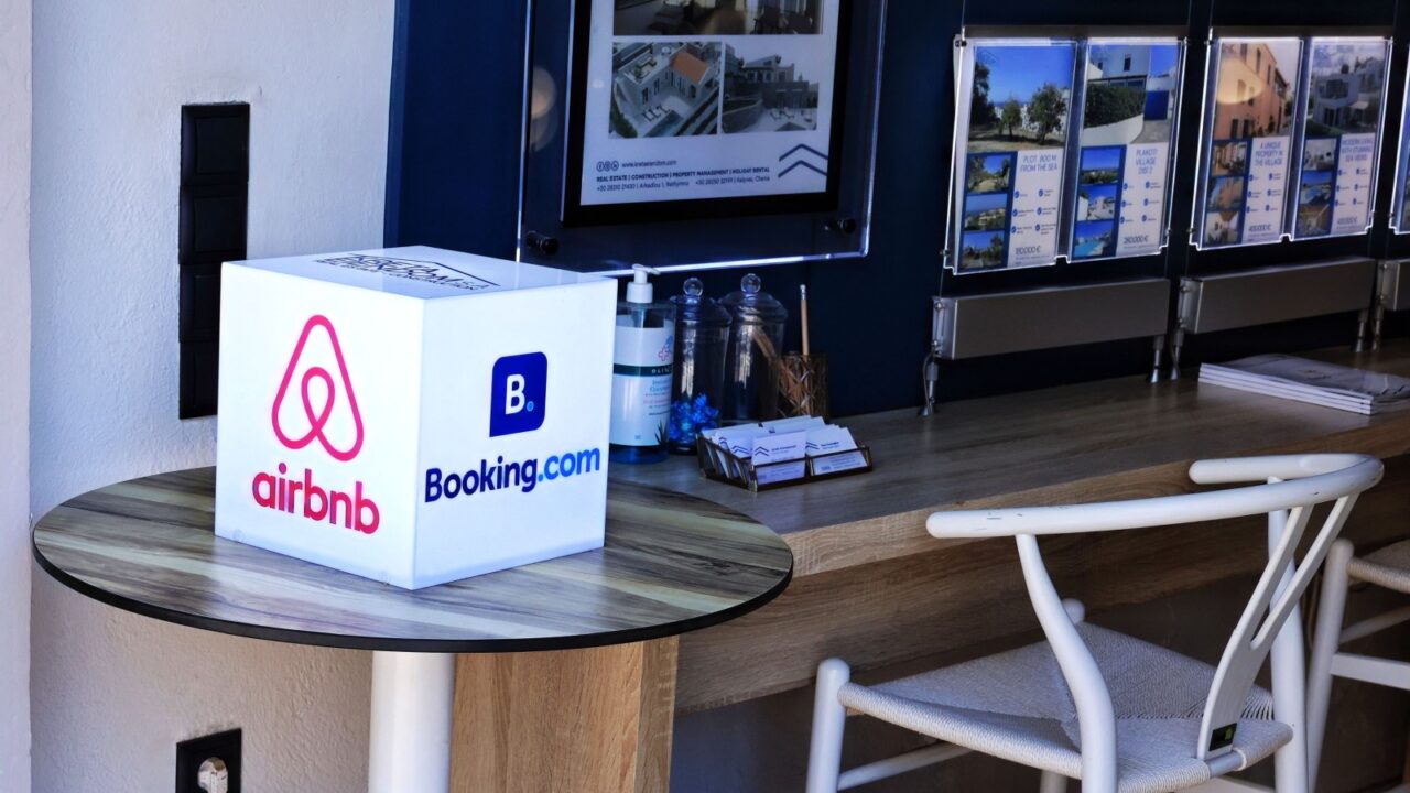 Airbnb and Booking.com logos in a real estate office with property listings for holiday rentals in Kissamos, Crete, Greece, July, 19, 2025