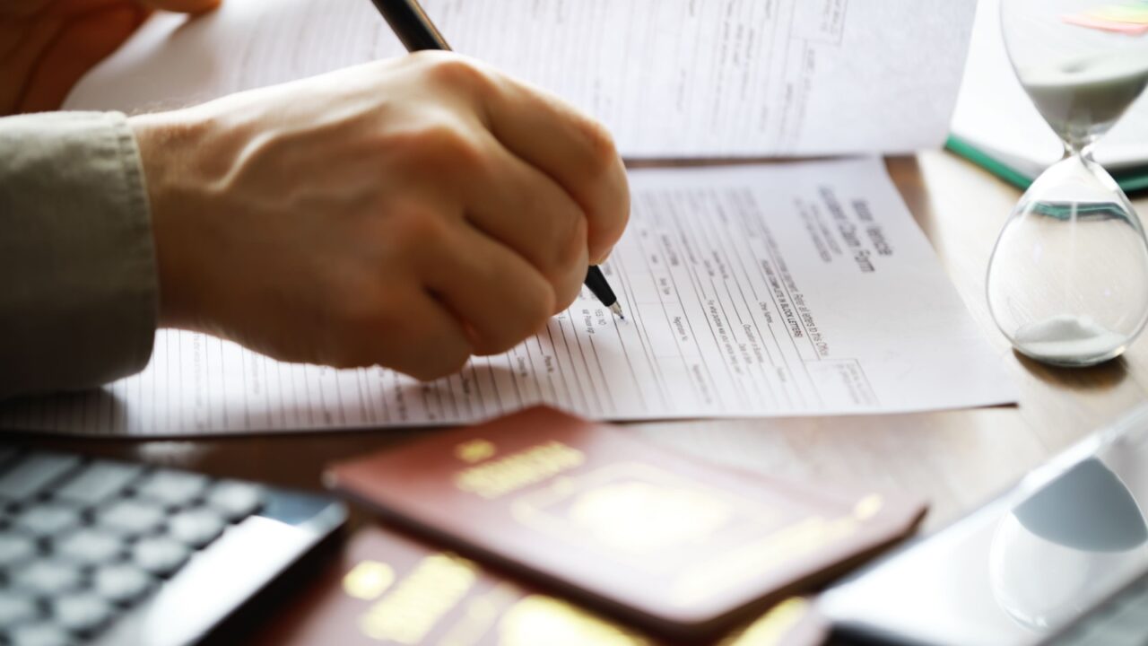 Filling Out Application Form with Passport and Hourglass - Immigration and Documentation Concept
