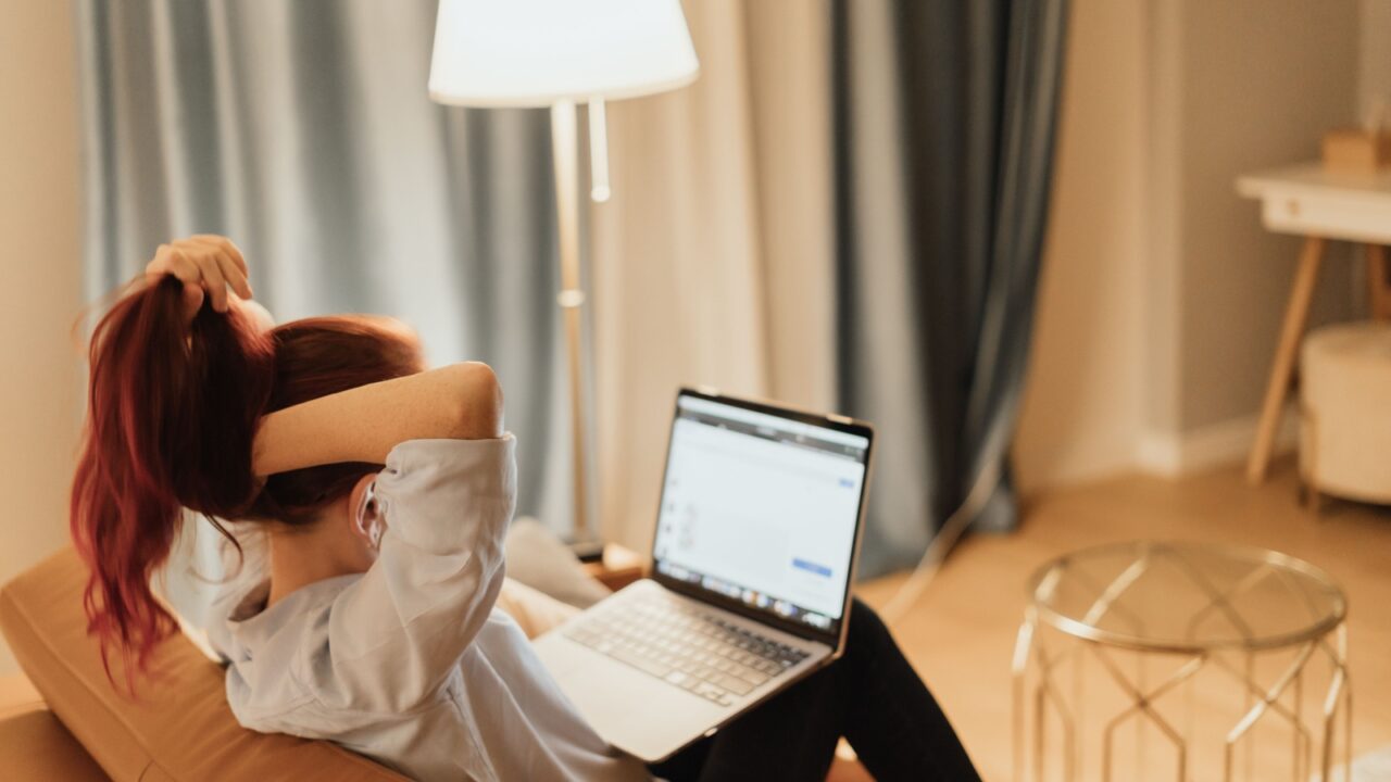 Young woman overwhelmed by online work from home while dealing with student loan stress and pressure of digital economy symbolizing financial anxiety and remote career uncertainty