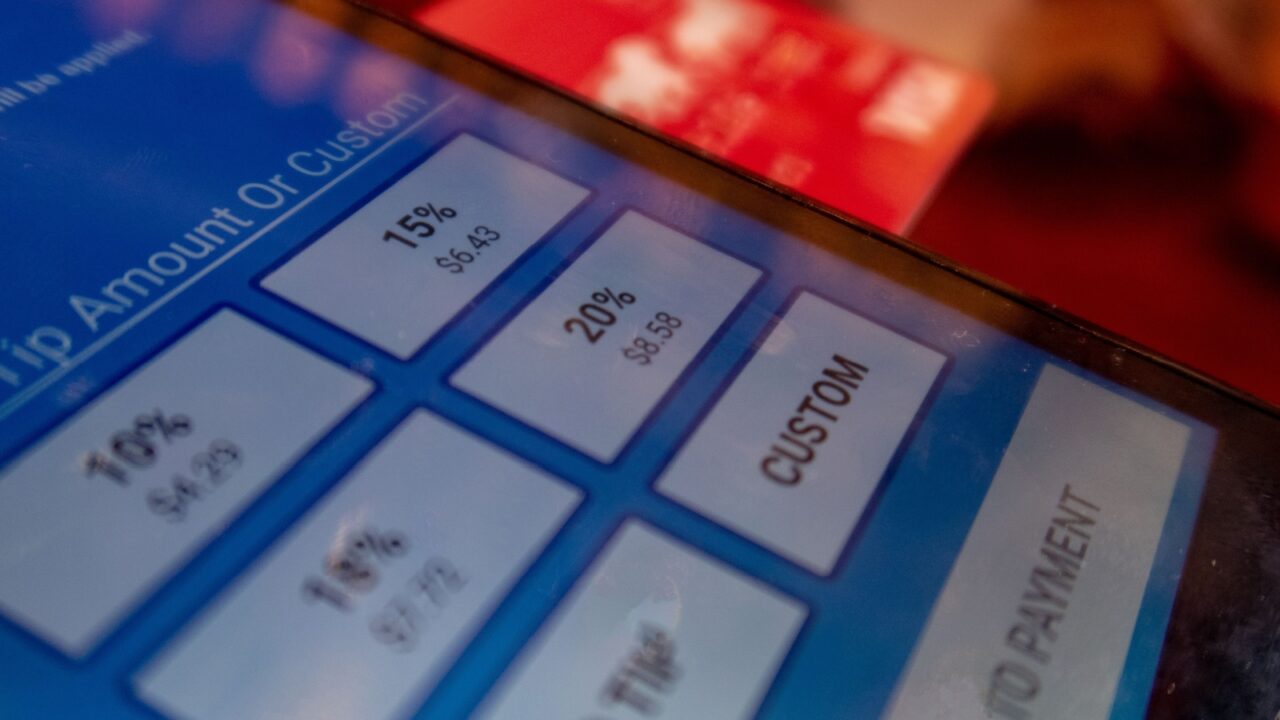 A Restaurant Handheld POS (Point of Sale) Device Taking a Credit Card Payment With Suggested Tip Amounts