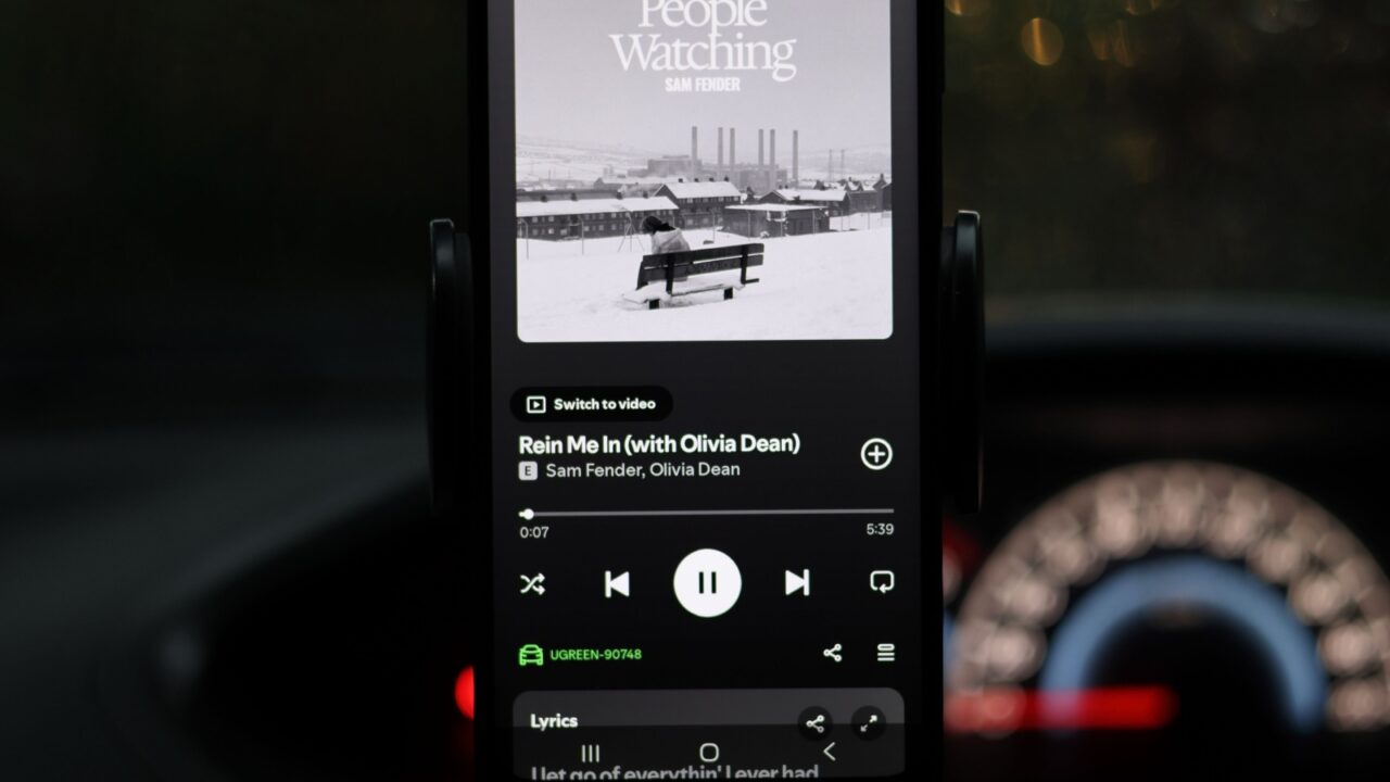 Quezon City, Philippines - Jan 10, 2026: The image displays a phone screen with a music player interface showing the song "Rein Me In" by Sam Fender featuring Olivia Dean. The track is from Fender's album People Watching.