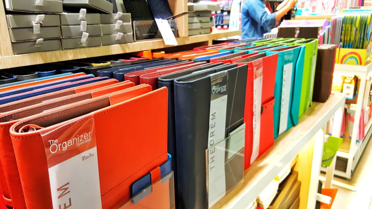 Sriracha, Chonburi THAILAND Dec 18, 2018: Women hand is holding Leather cover book for student or office stationary display in supermarket shelf