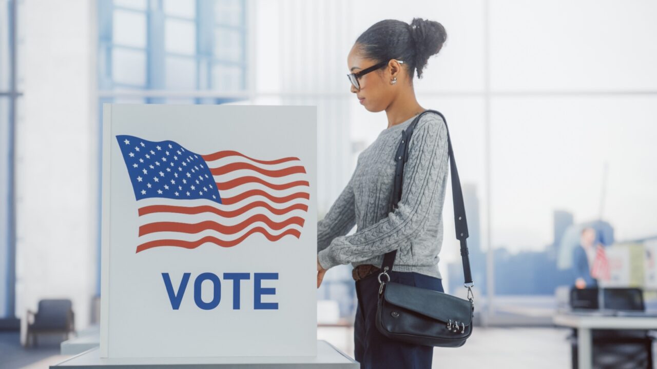 American People on the Election Day in the United States of America. Diverse People Using Voting Booths to Give Their Vote to a Preferred Candidate. Beautiful Black Female Filling Out Her Ballot